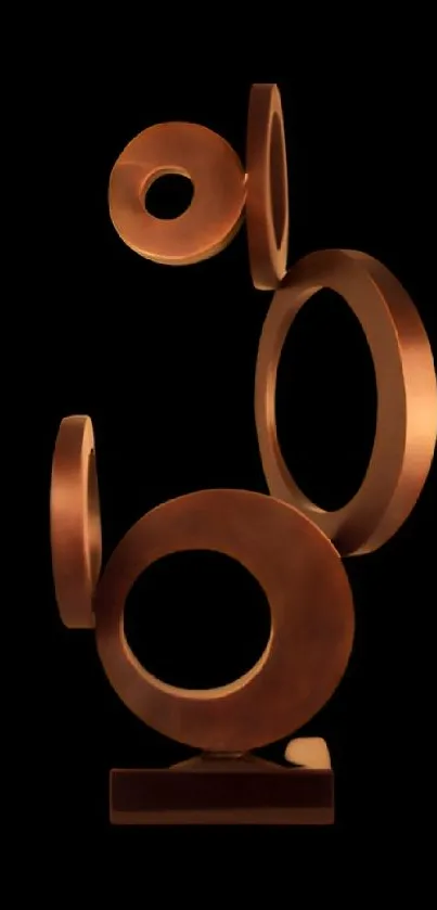 Elegant bronze sculpture rings on black wallpaper.