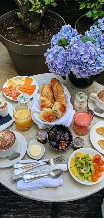 A beautifully set brunch table with pastries, fruit, and vivid hydrangeas.