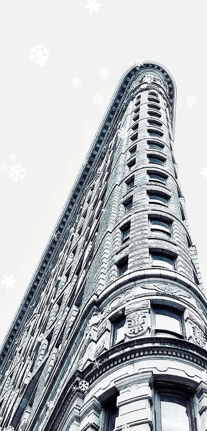 Image of a tall building with snowflakes against a light gray background.