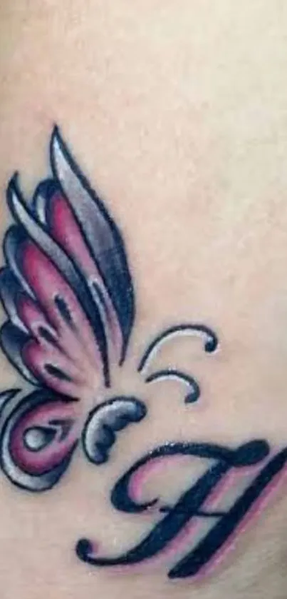 Intricate butterfly tattoo with pink wings and black detailing on warm beige skin.