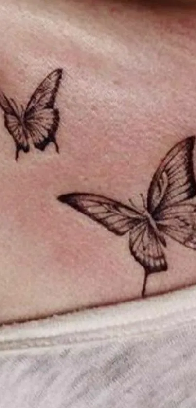 Elegant tattoo of two butterflies on skin.