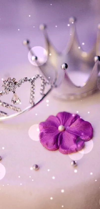 Elegant white cake with crowns and a purple flower decoration.