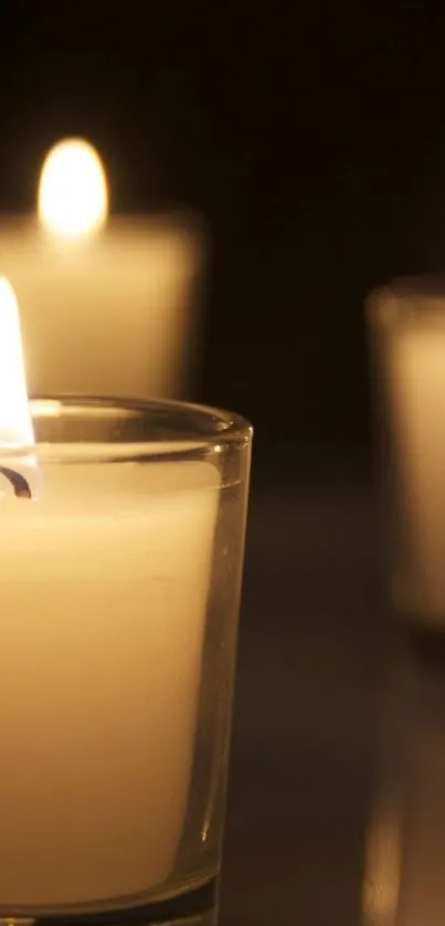 Serene candlelight in elegant glass votives glowing softly in the dark.