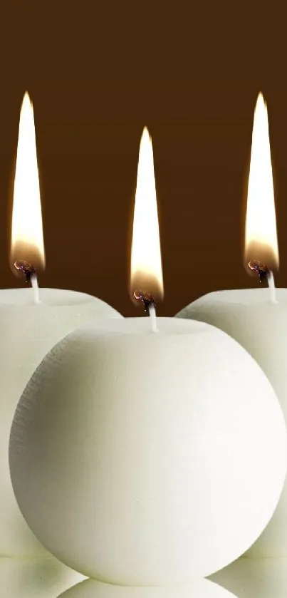 Three lit candles against a warm brown background for mobile wallpaper.