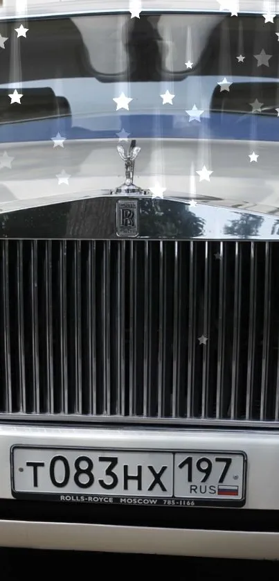 Luxury car front view with chrome grille and stars on glass.