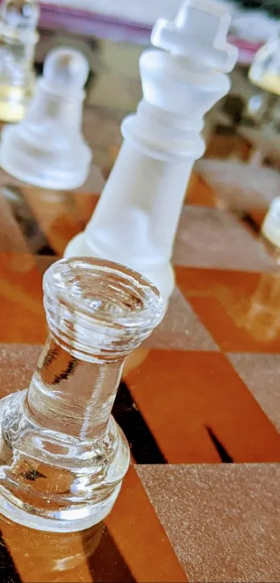 Close-up of frosted glass chess pieces on a brown chessboard.