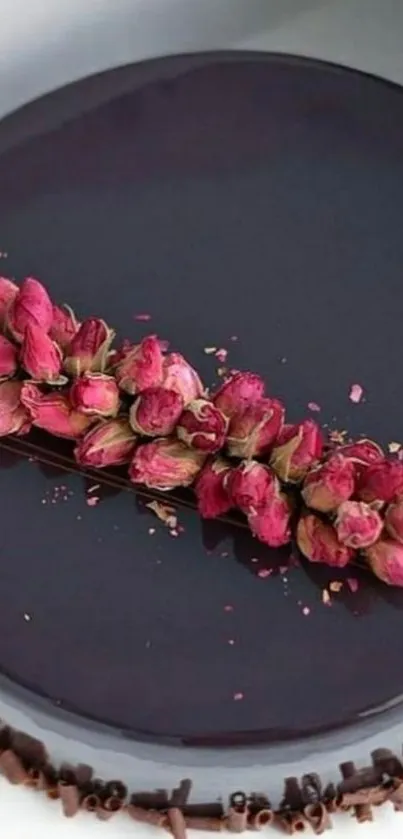 Dark chocolate cake with pink roses on top.