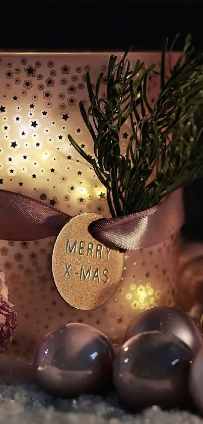 Rose gold Christmas candle with decorative pine and ornaments.