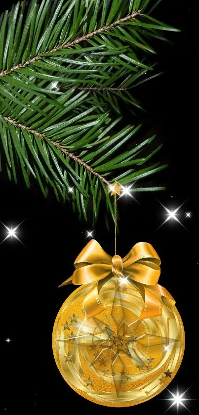 Gold Christmas ornament on pine branch with black background.