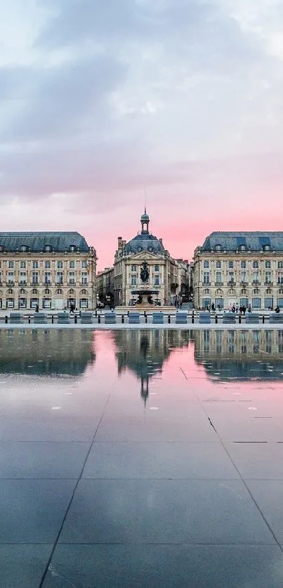 Serene sunset cityscape with reflection in water.