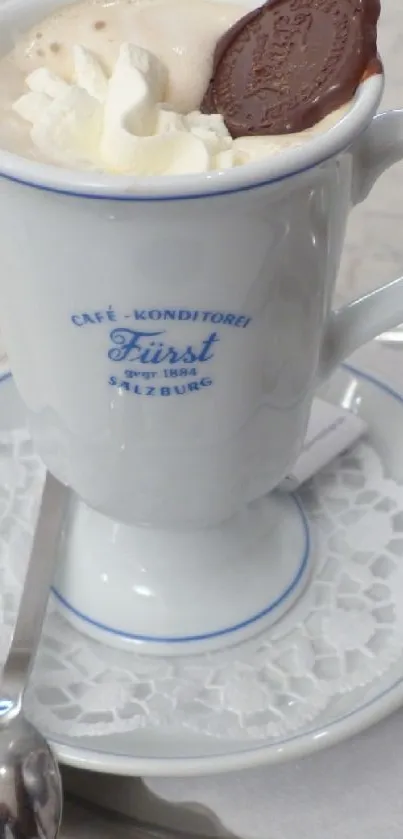 Elegant coffee mug with whipped cream and chocolate on a marble table.