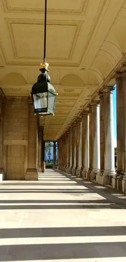 Elegant corridor with columns and a hanging lamp under soft daylight.