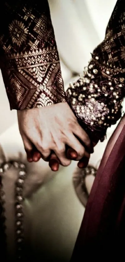 A couple holds hands wearing intricate, traditional attire.