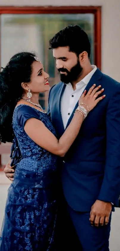 Elegant couple in dark blue attire with a romantic embrace.