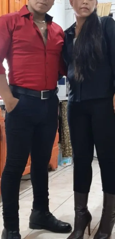 Stylish couple posing in a modern kitchen with elegant attire and decor.