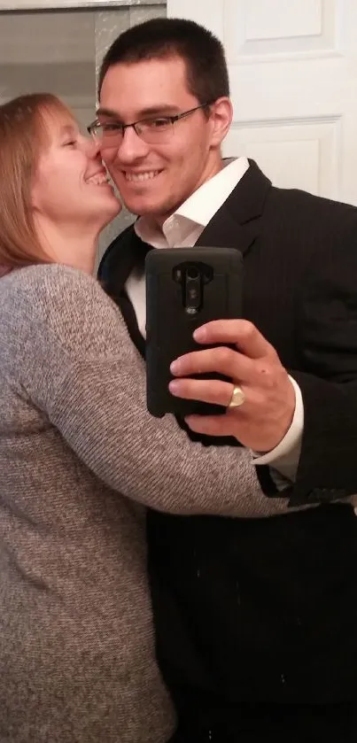 Couple taking a mirror selfie in a stylish and elegant setting.