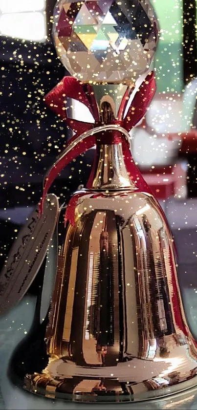 Luxurious gold bell with crystal top and red ribbon against a sparkling background.