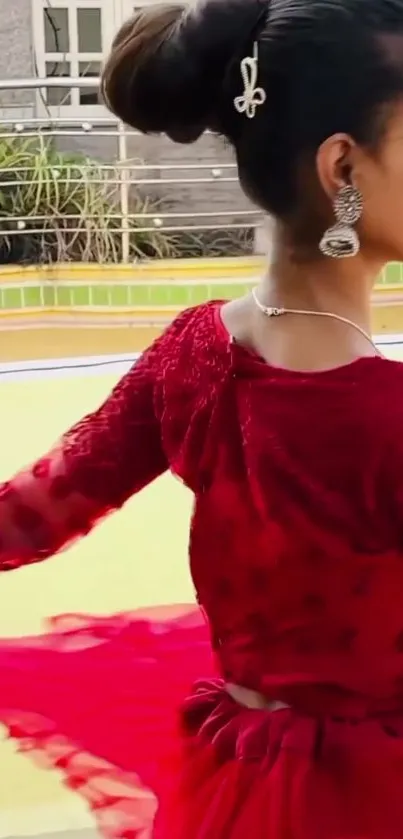 Young woman twirls in an elegant red dress, exuding grace and style.