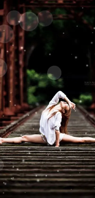 Ballet dancer elegantly poses on railway tracks, capturing rustic beauty and grace.