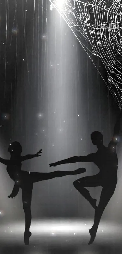 Silhouette dancers with spider web in spotlight backdrop.