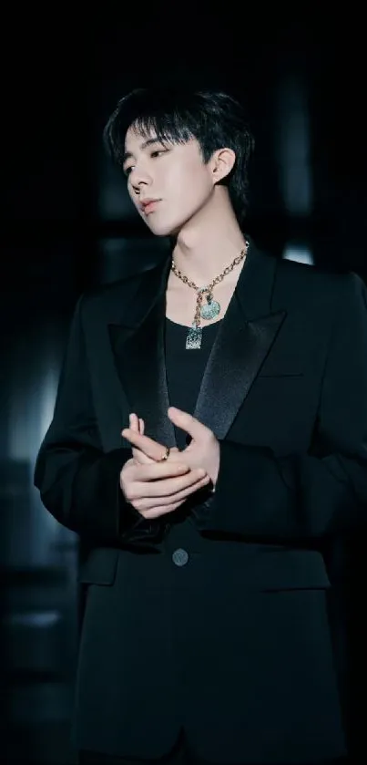 Person in an elegant dark suit with a dramatic backdrop.