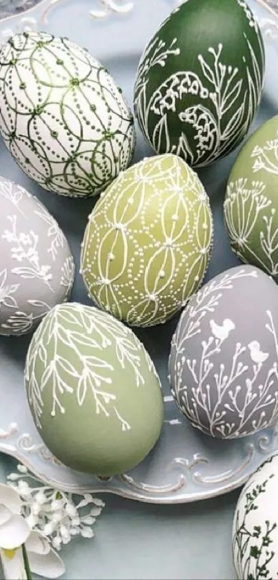 Elegant decorative Easter eggs with soft green and white designs on a plate.