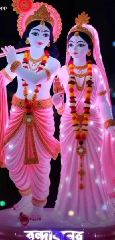 Pink adorned deities with floral garlands.