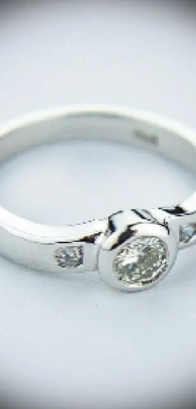 Minimalist wallpaper featuring a diamond ring on a silver band.