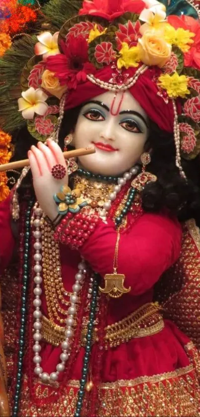 Divine figure playing flute in vibrant red attire with floral embellishments.