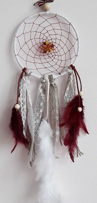 Dreamcatcher with lace and feathers on white background.