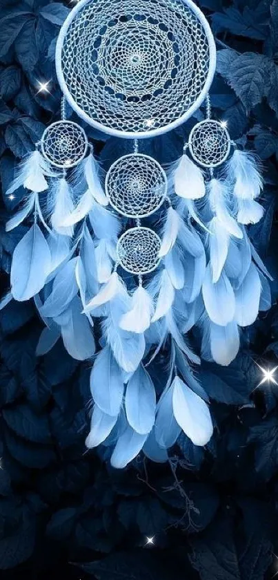 Blue dreamcatcher with feathers on a dark leafy background.