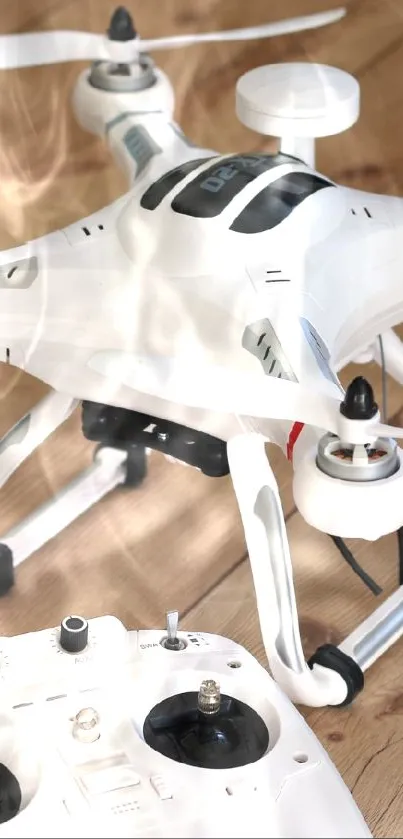 White drone with remote on wooden floor.