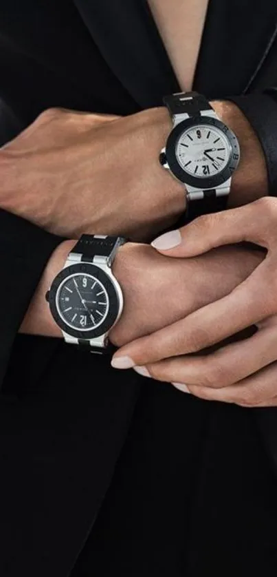 Elegant hands wearing two stylish black watches against a silky black suit background.