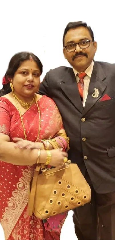 Elegant couple in traditional ethnic attire on a neutral background.