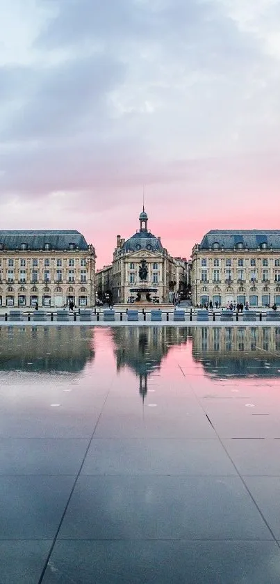 Elegant city architecture reflected on water at sunset with blue sky.