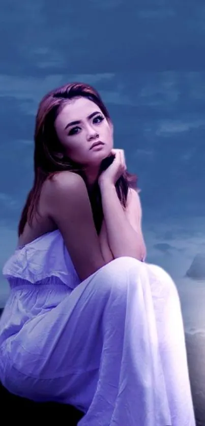 Woman in a white dress sitting thoughtfully against a deep blue night background.