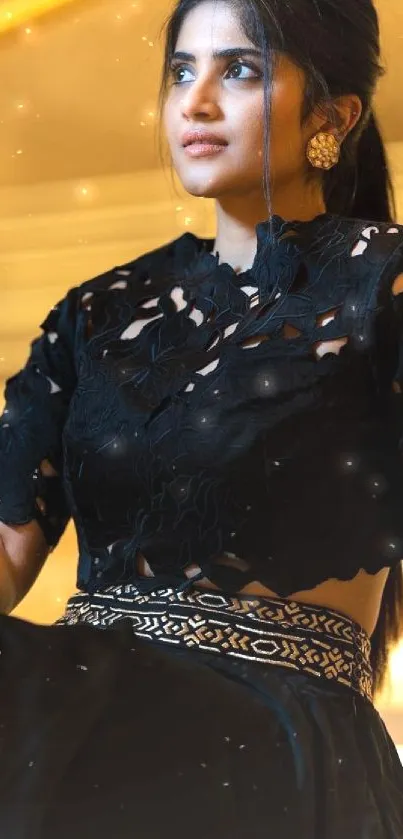 Person in a black ornate dress sitting elegantly on stairs.