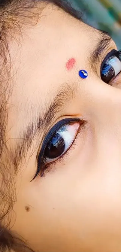 Close-up of an eye with traditional adornments and vivid color.