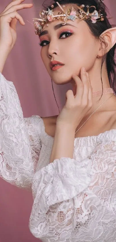 Woman in lace with floral crown against pink backdrop.