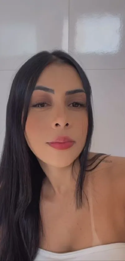 Elegant female portrait with dark hair and serene expression on a soft background.