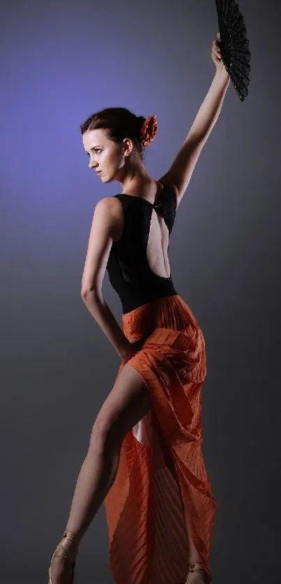 Elegant flamenco dancer poses gracefully with a vibrant orange skirt.