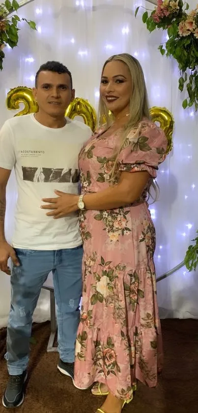 Couple at floral-themed celebration with lights.