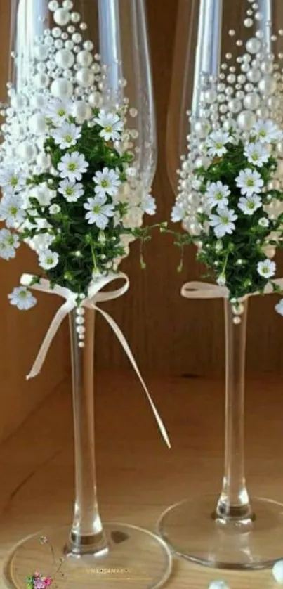 Champagne glasses with white flowers and pearls.