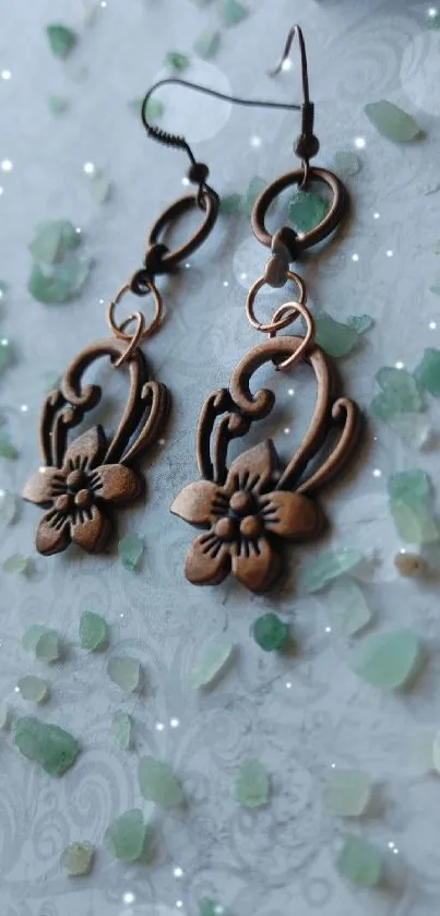 Elegant bronze floral earrings on light background.