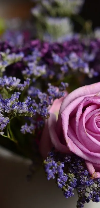 Pink rose and purple flowers in a white vase.
