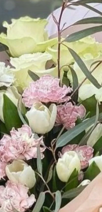 Elegant bouquet of pastel pink and white flowers with lush green leaves.