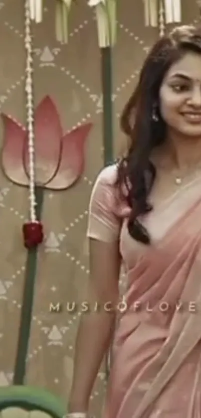 Woman in pink sari with a floral backdrop.