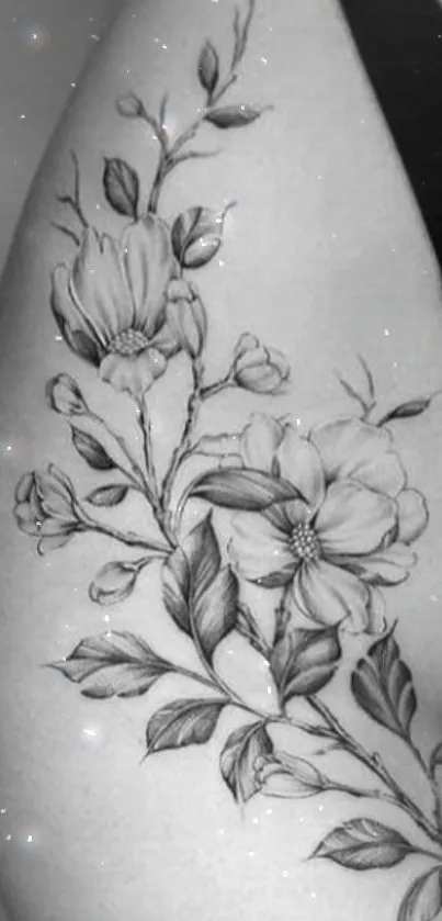 Black and white floral tattoo on arm with elegant details.