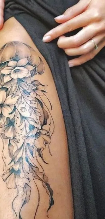 Floral thigh tattoo with intricate black ink design.