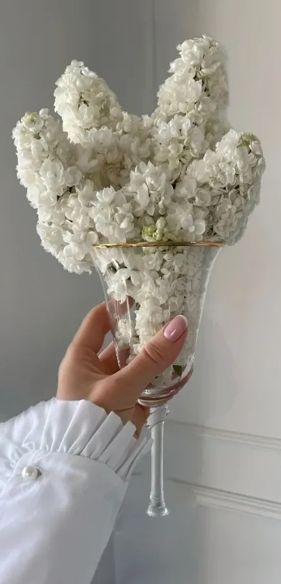 Elegant white flowers in a clear glass vase against a minimalist background.